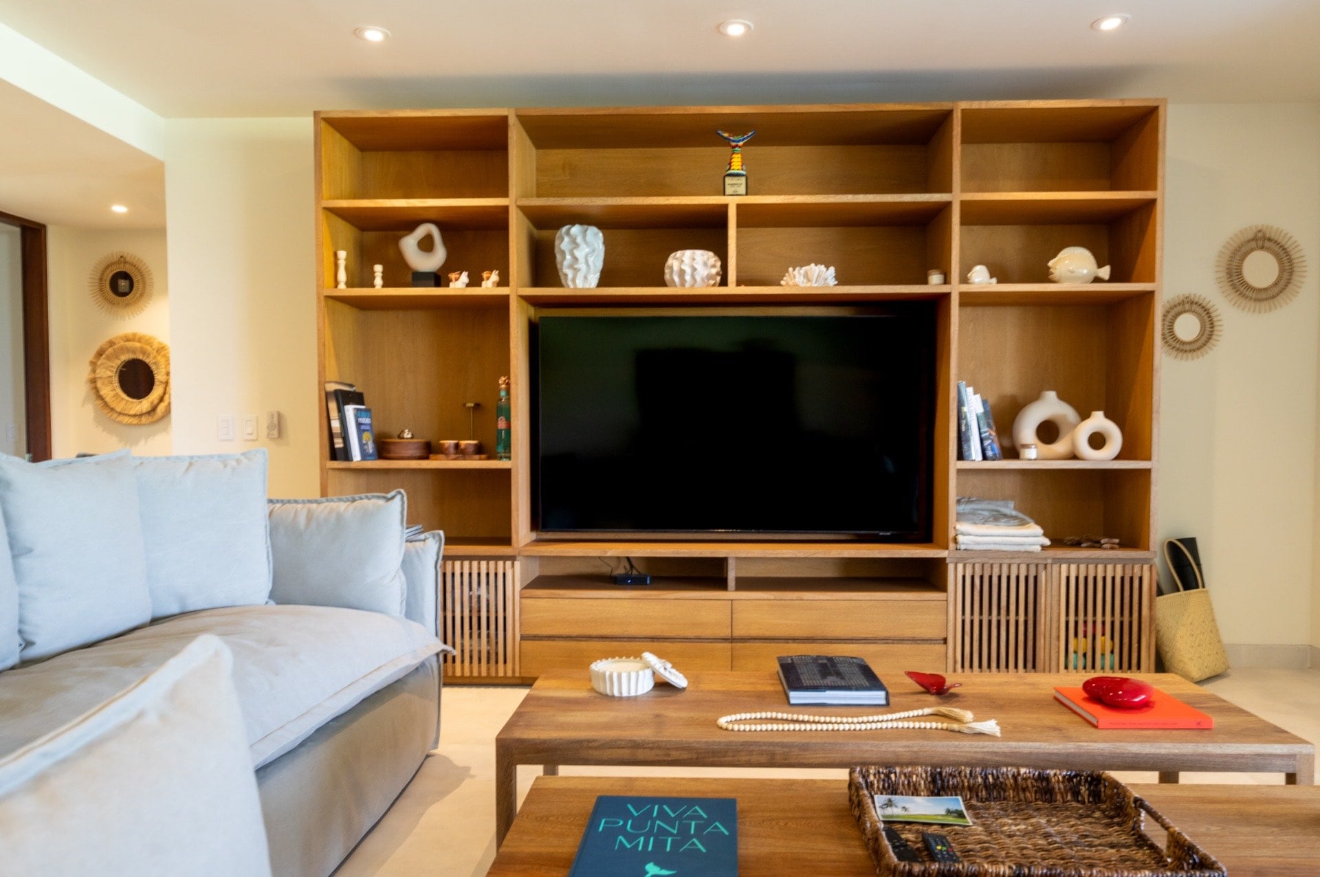 Condo El Encanto 401 living room sofas facing a television within open shelves — Punta Mita Nayarit, Mexico