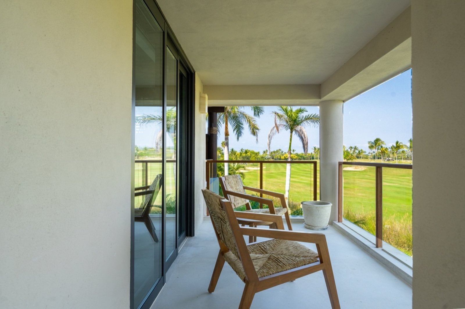 Condo El Encanto 401 covered balcony with two chairs overlooking palms and golf — Punta Mita Nayarit, Mexico