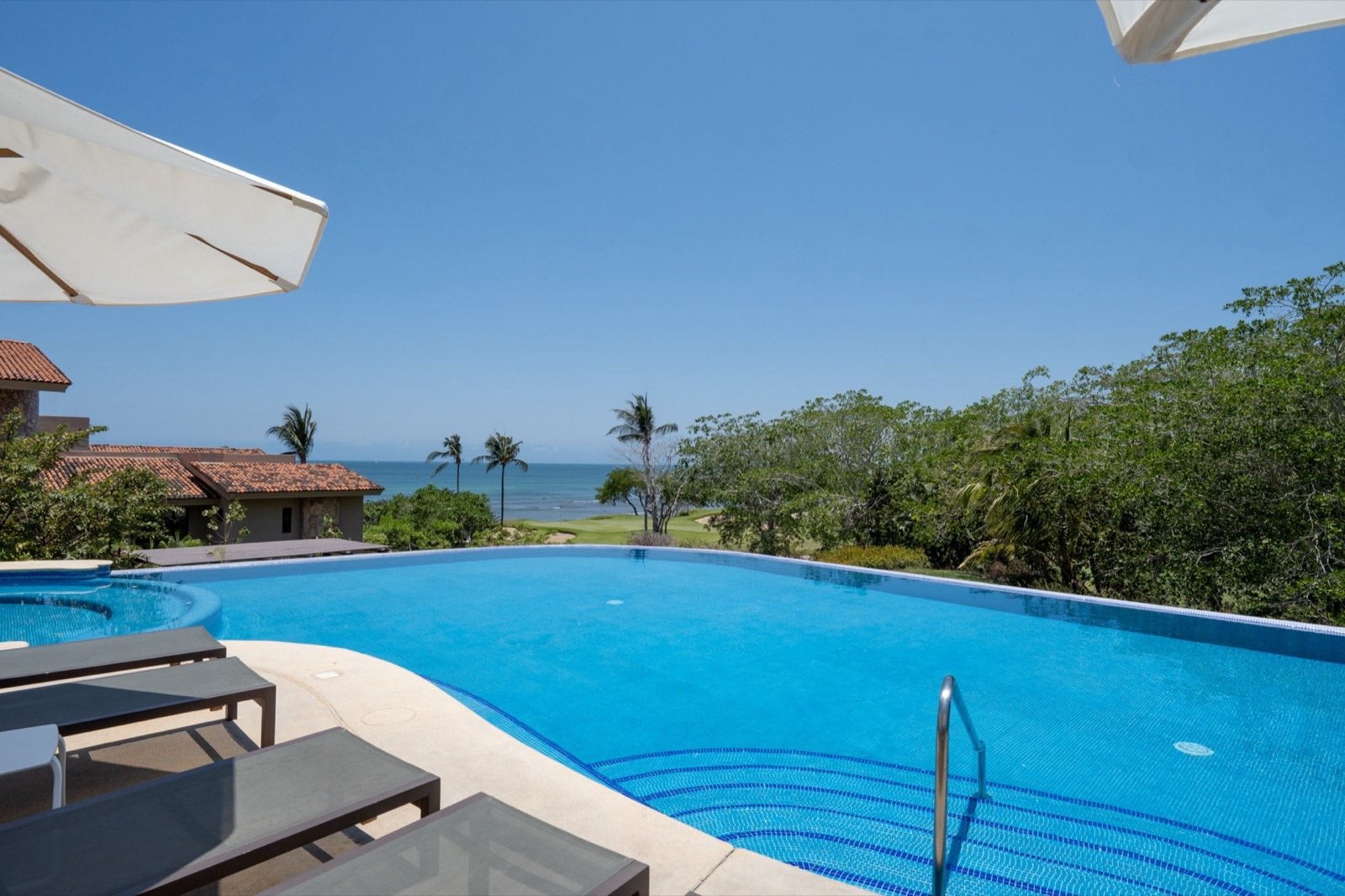 Condo Hacienda de Mita 705 curved pool with loungers and ocean beyond — Punta Mita Nayarit, Mexico