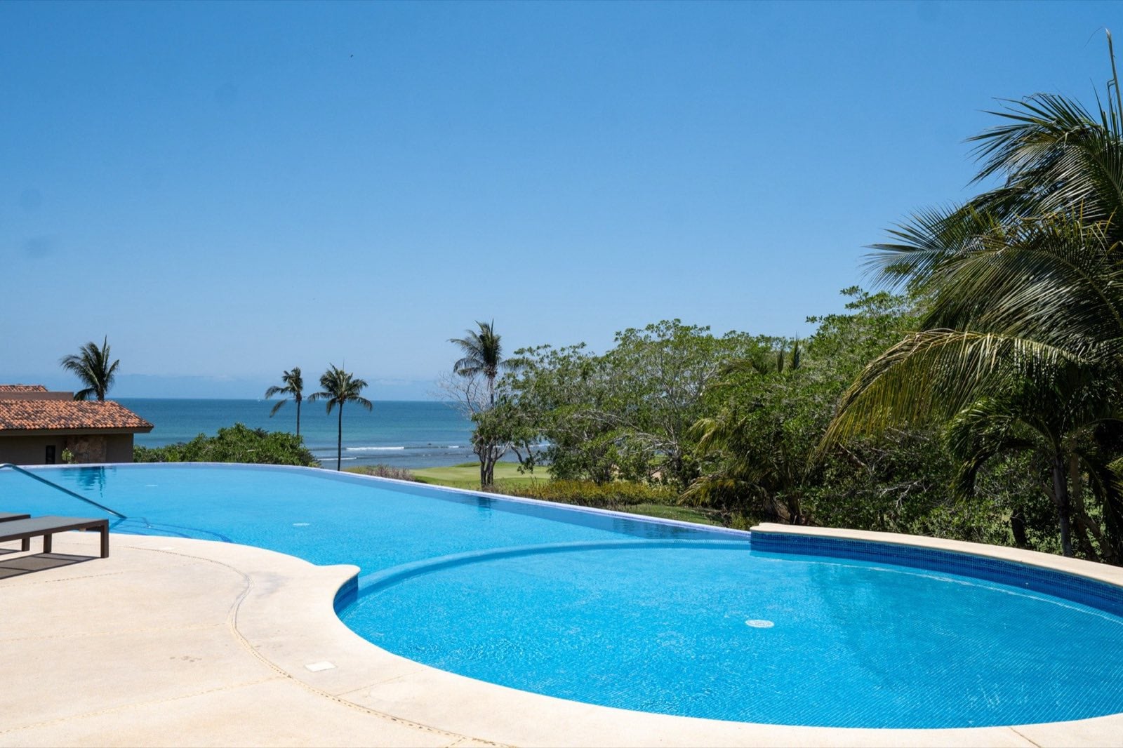 Condo Hacienda de Mita 705 curved blue pool overlooking trees and ocean — Punta Mita Nayarit, Mexico