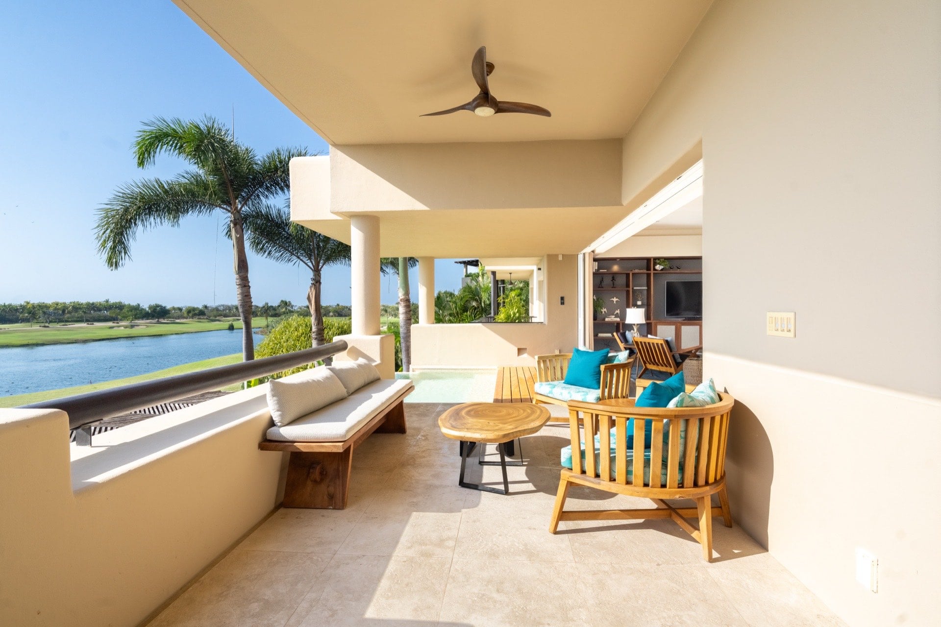 Condo El Encanto 602 covered balcony with a long bench and chairs beside the lagoon — Punta Mita Nayarit, Mexico