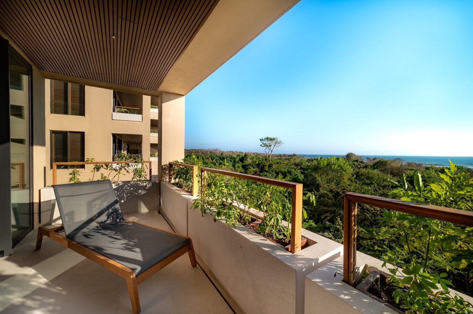 Surf Residences 312 single lounge chair on a balcony above treetops — Punta Mita Nayarit, Mexico
