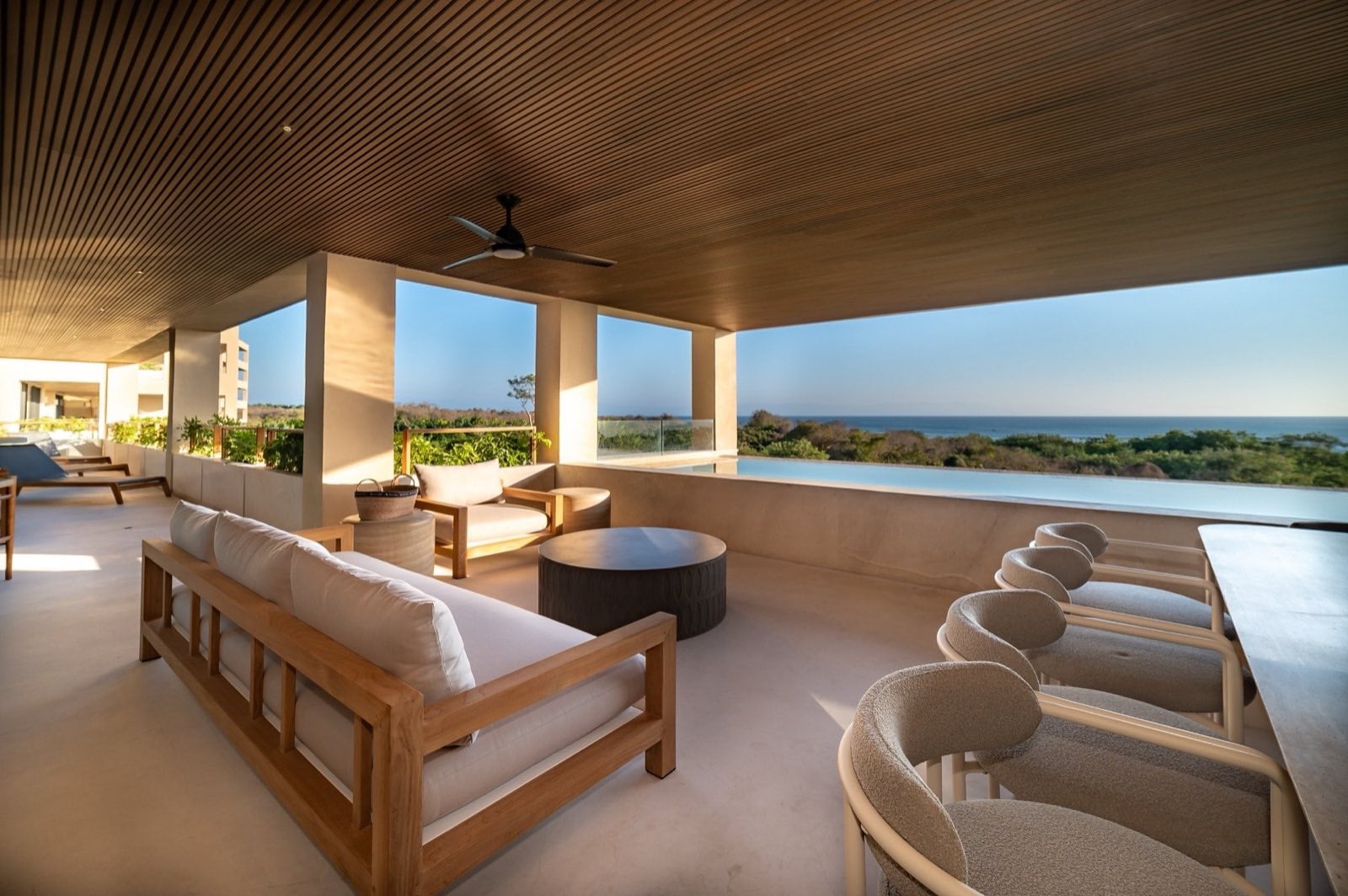 Surf Residences 312 covered terrace with a sofa, stools, and ocean view — Punta Mita Nayarit, Mexico