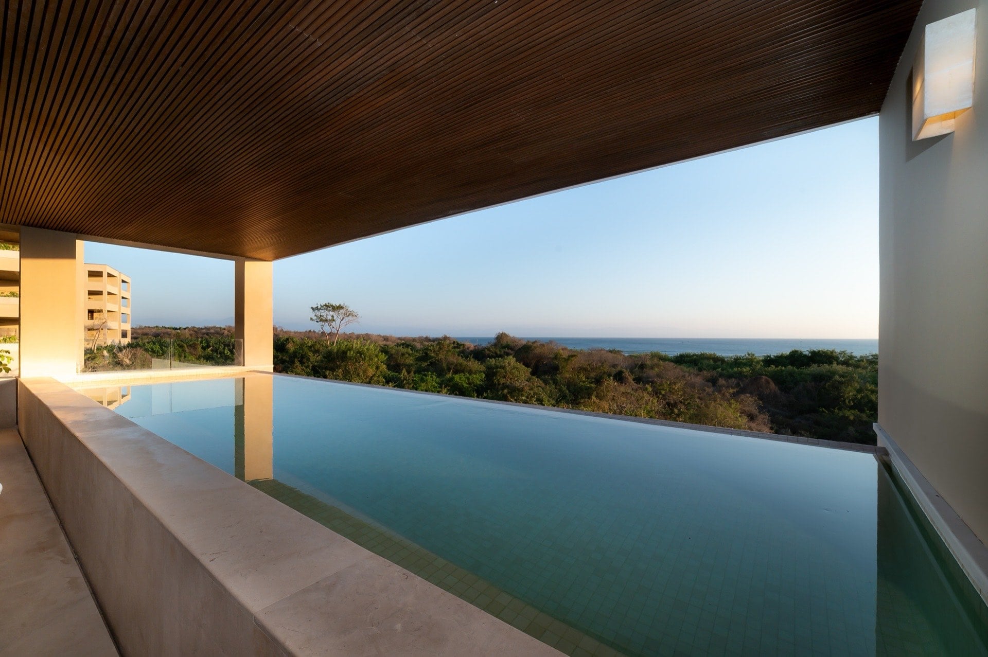 Surf Residences 312 long covered pool overlooking treetops and the ocean — Punta Mita Nayarit, Mexico