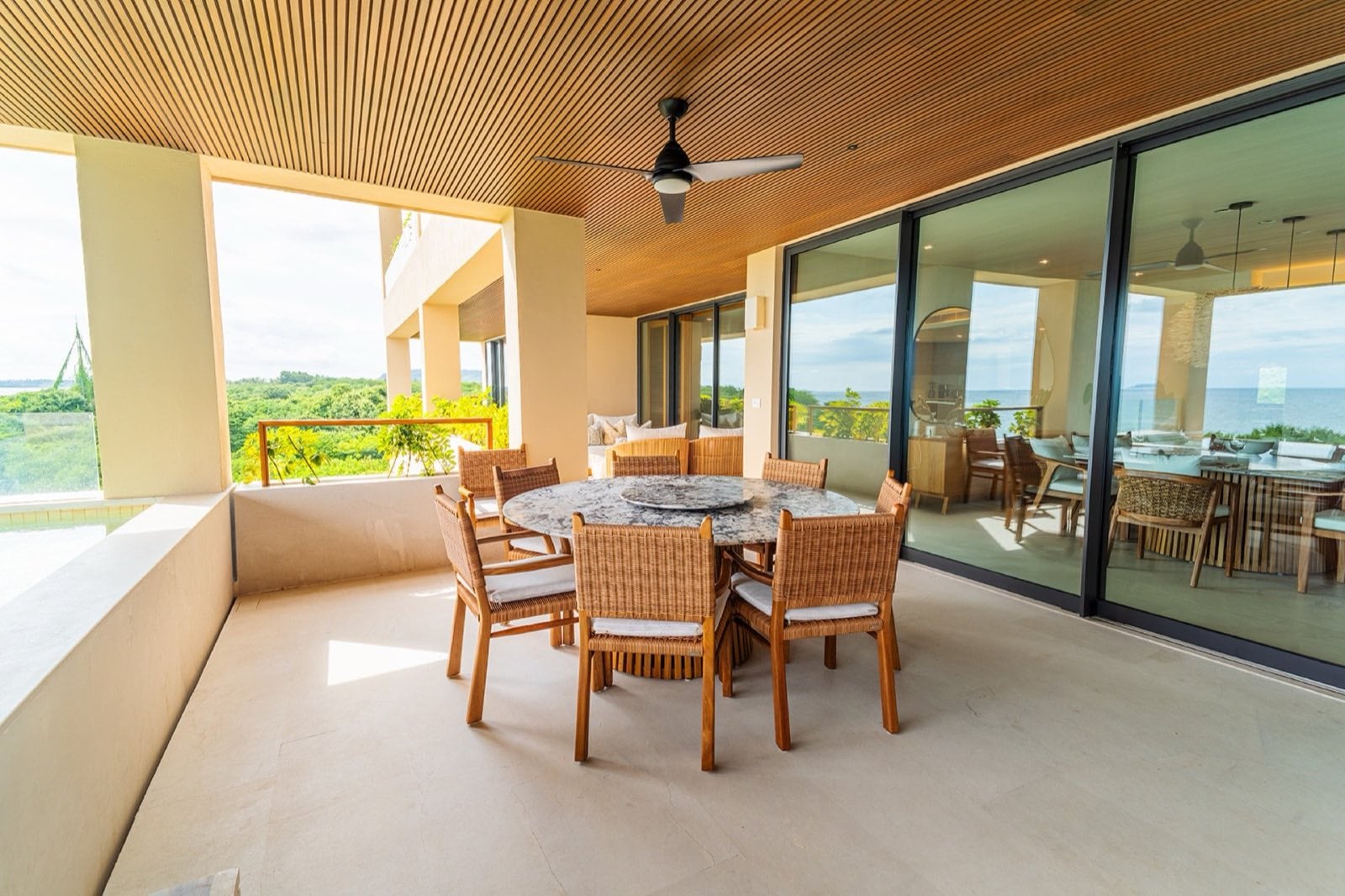 Condo Surf Residences 321 round dining table on a covered terrace beside glass doors — Punta Mita Nayarit, Mexico