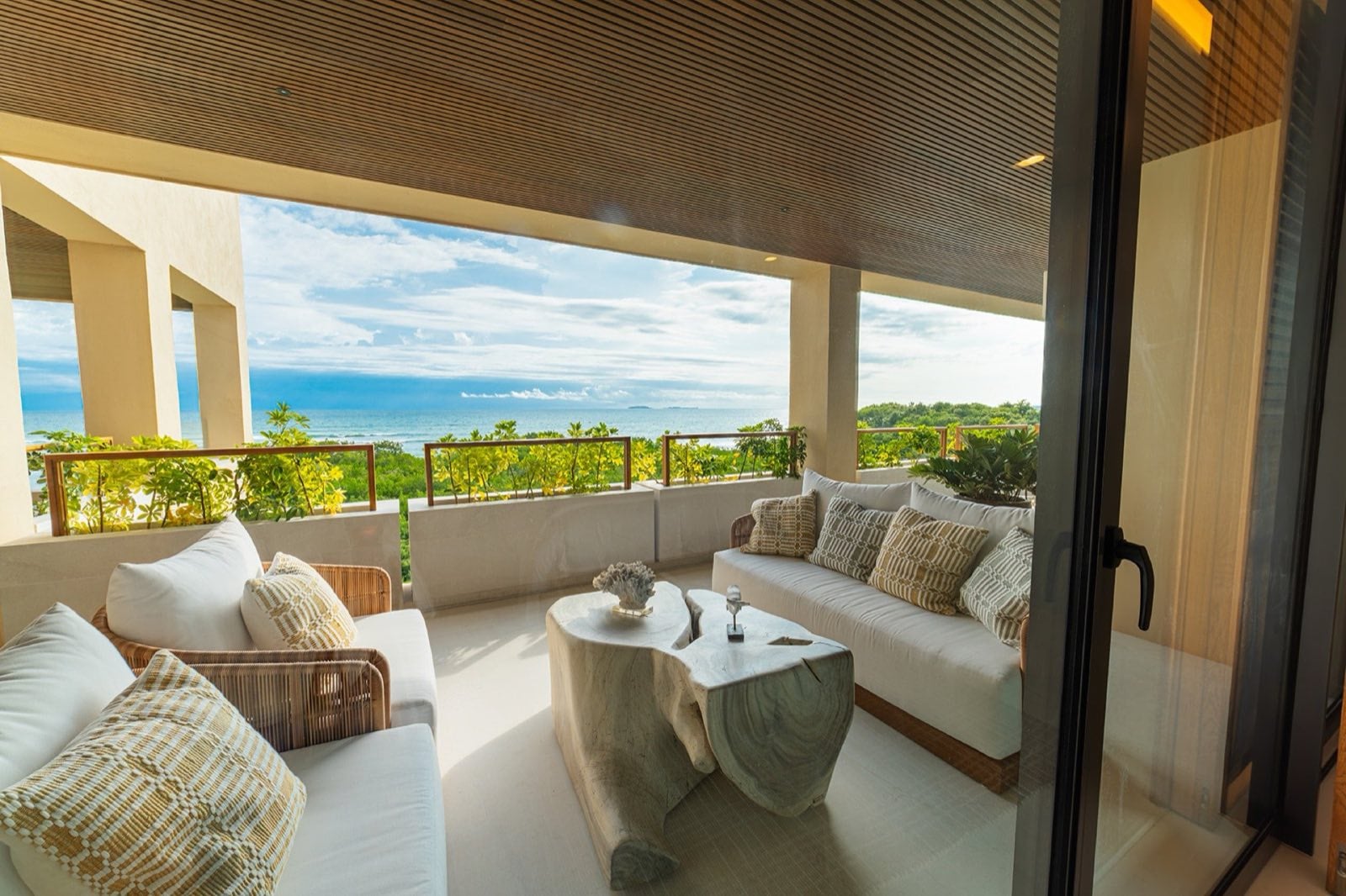 Condo Surf Residences 321 covered balcony lounge with white sofas and a sculpted table — Punta Mita Nayarit, Mexico