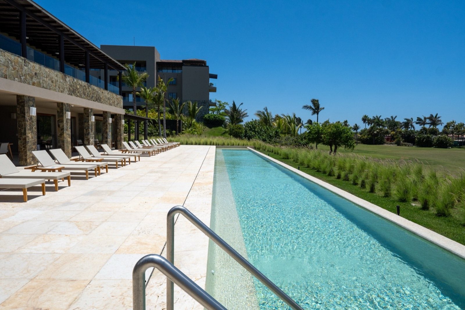 Condo Tau 131 long lap pool with a row of loungers beside the building — Punta Mita Nayarit, Mexico