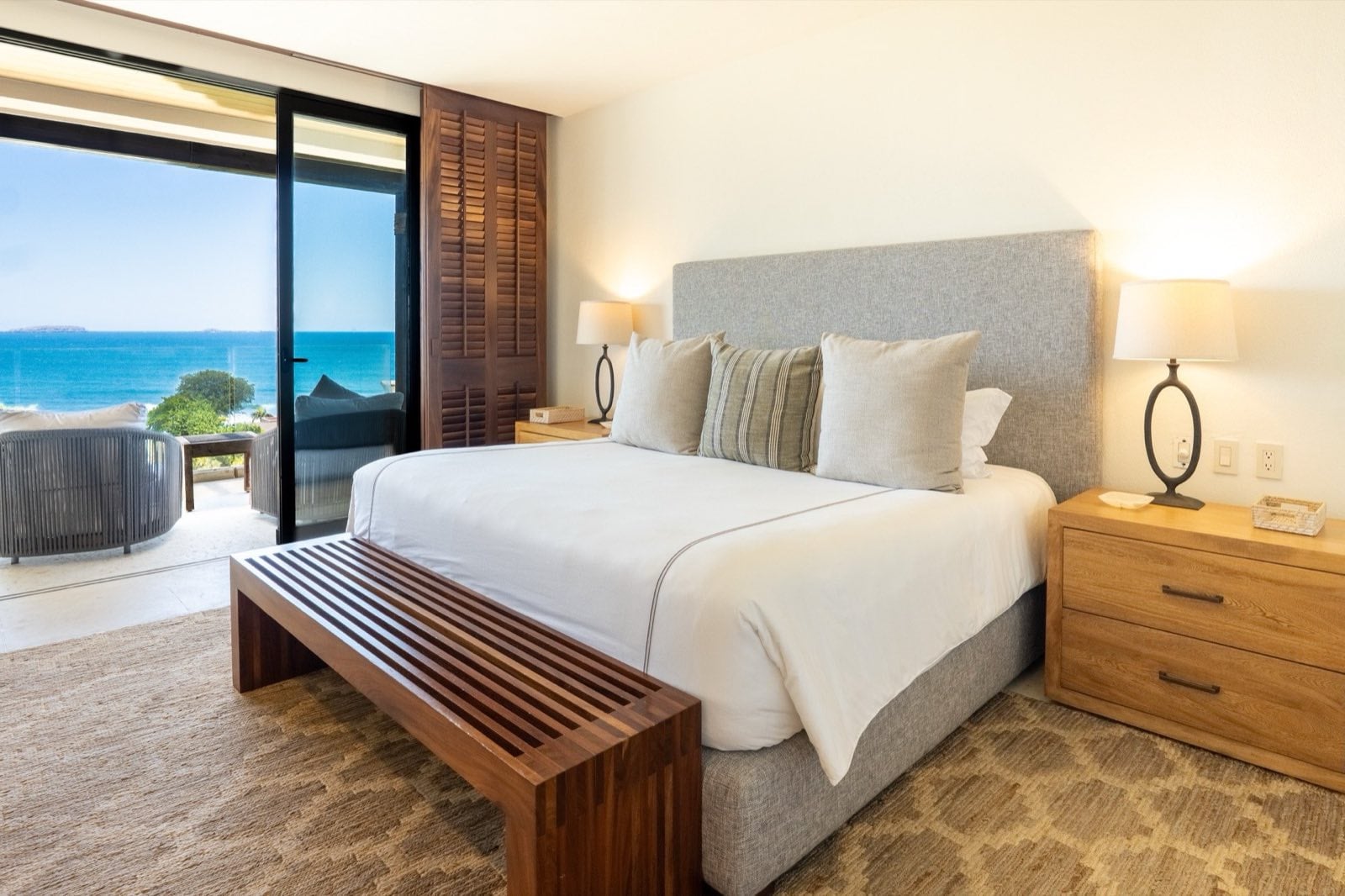 Condo Tau 131 bedroom with two bedside lamps and doors to an ocean-view terrace — Punta Mita Nayarit, Mexico