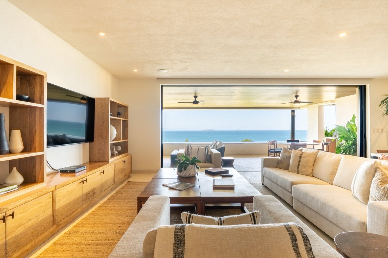 Condo Tau 131 living room with sofas and a media wall open to the ocean terrace — Punta Mita Nayarit, Mexico