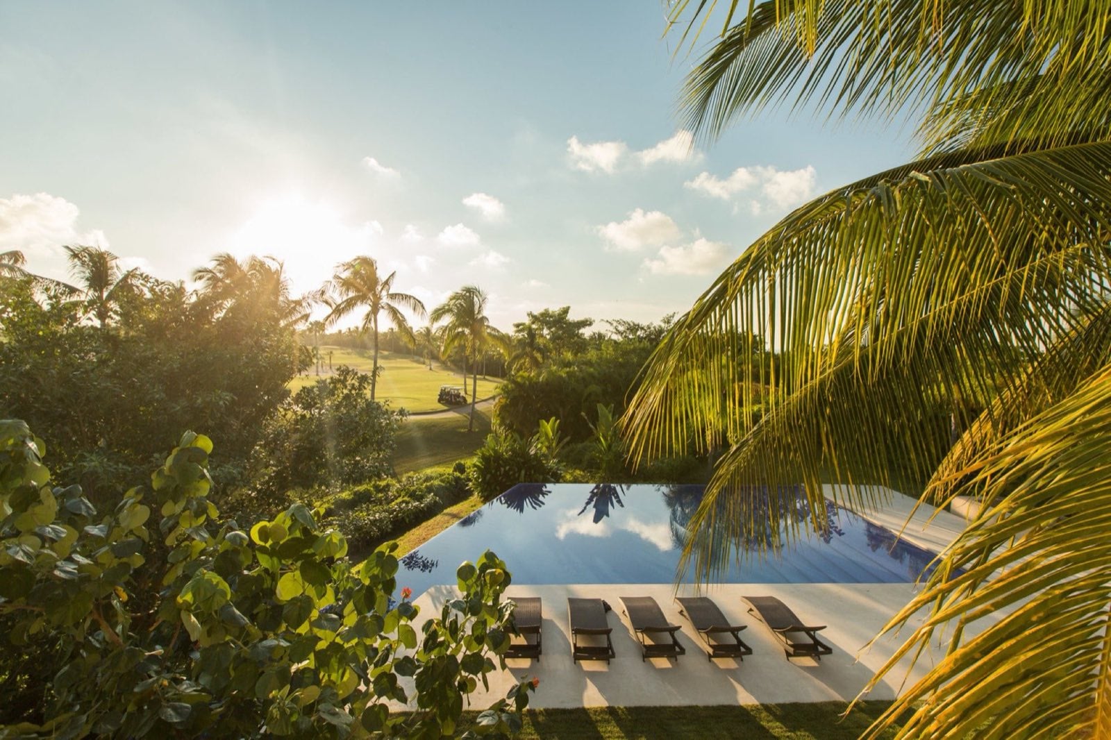 Condo Terazzas P23 pool edge with loungers overlooking the golf course through palms — Punta Mita Nayarit, Mexico