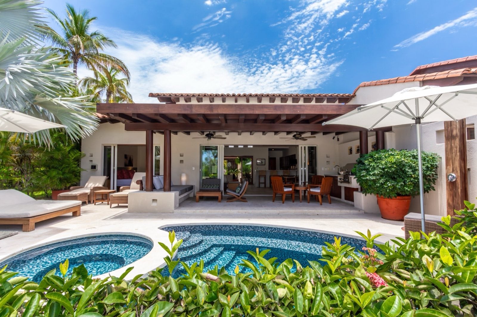 Villa Cazadores exterior behind a curved pool and round basin — Punta Mita Nayarit, Mexico
