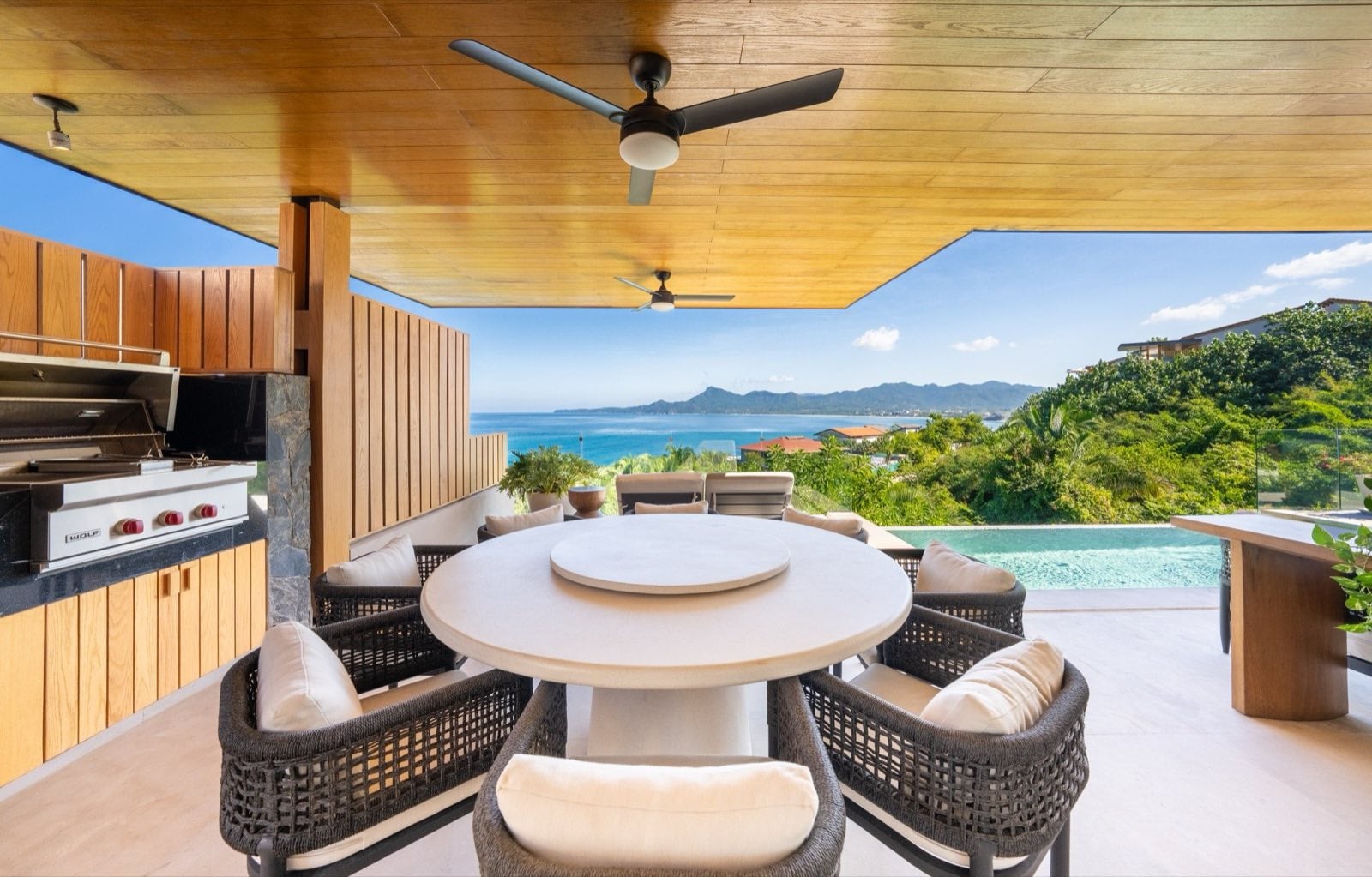 Villa La Vista covered terrace with a round dining table, grill, and pool — Punta Mita Nayarit, Mexico