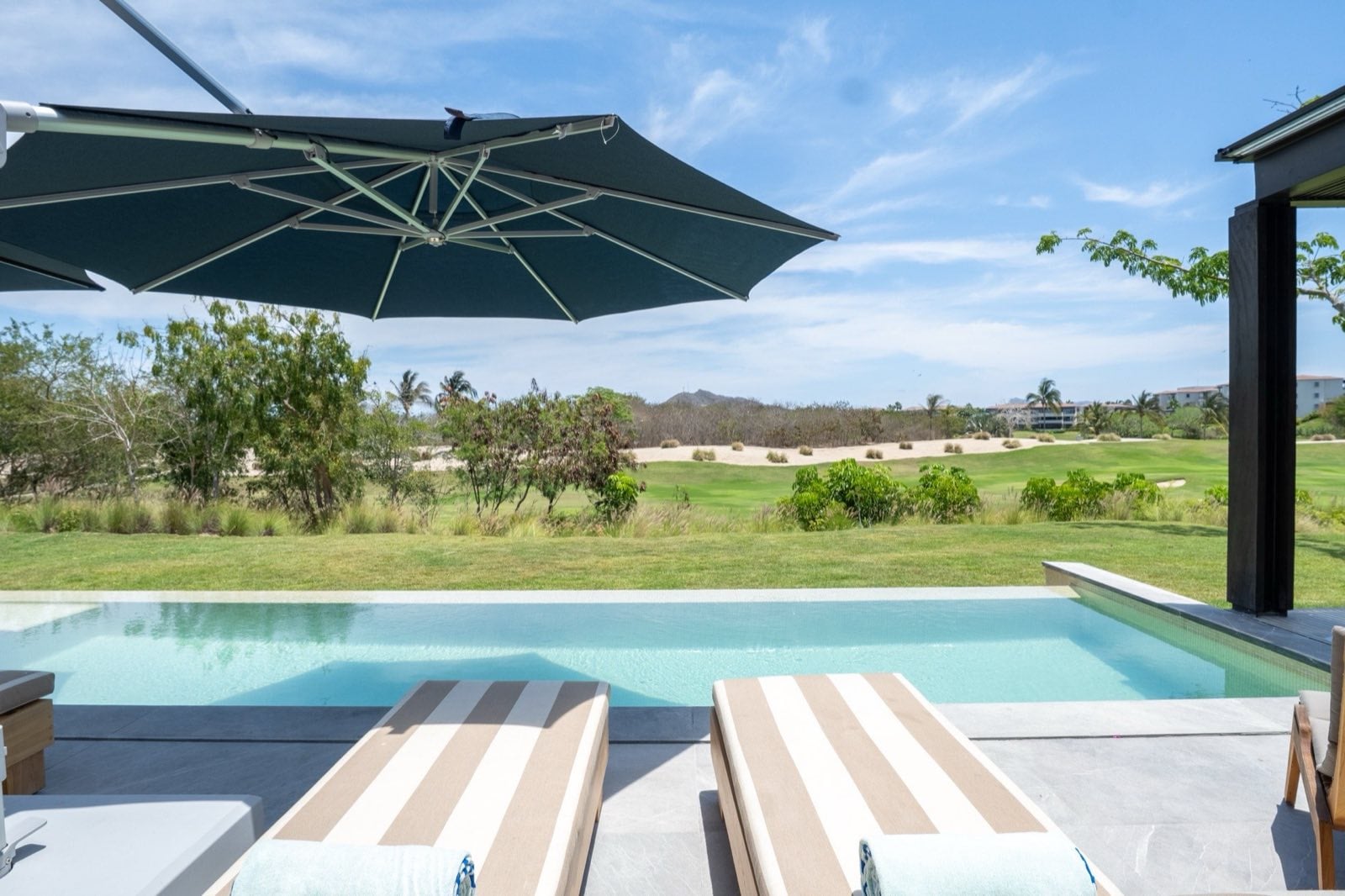Villa Porta Fortuna 6 striped loungers under an umbrella by the pool — Punta Mita Nayarit, Mexico