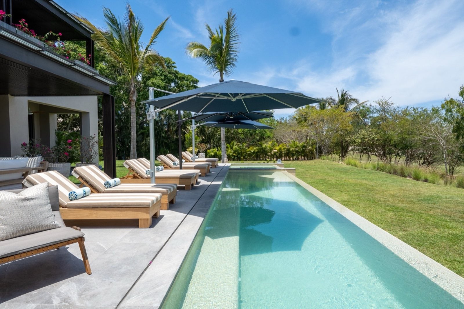 Villa Porta Fortuna 6 long pool beside loungers and a grassy lawn — Punta Mita Nayarit, Mexico