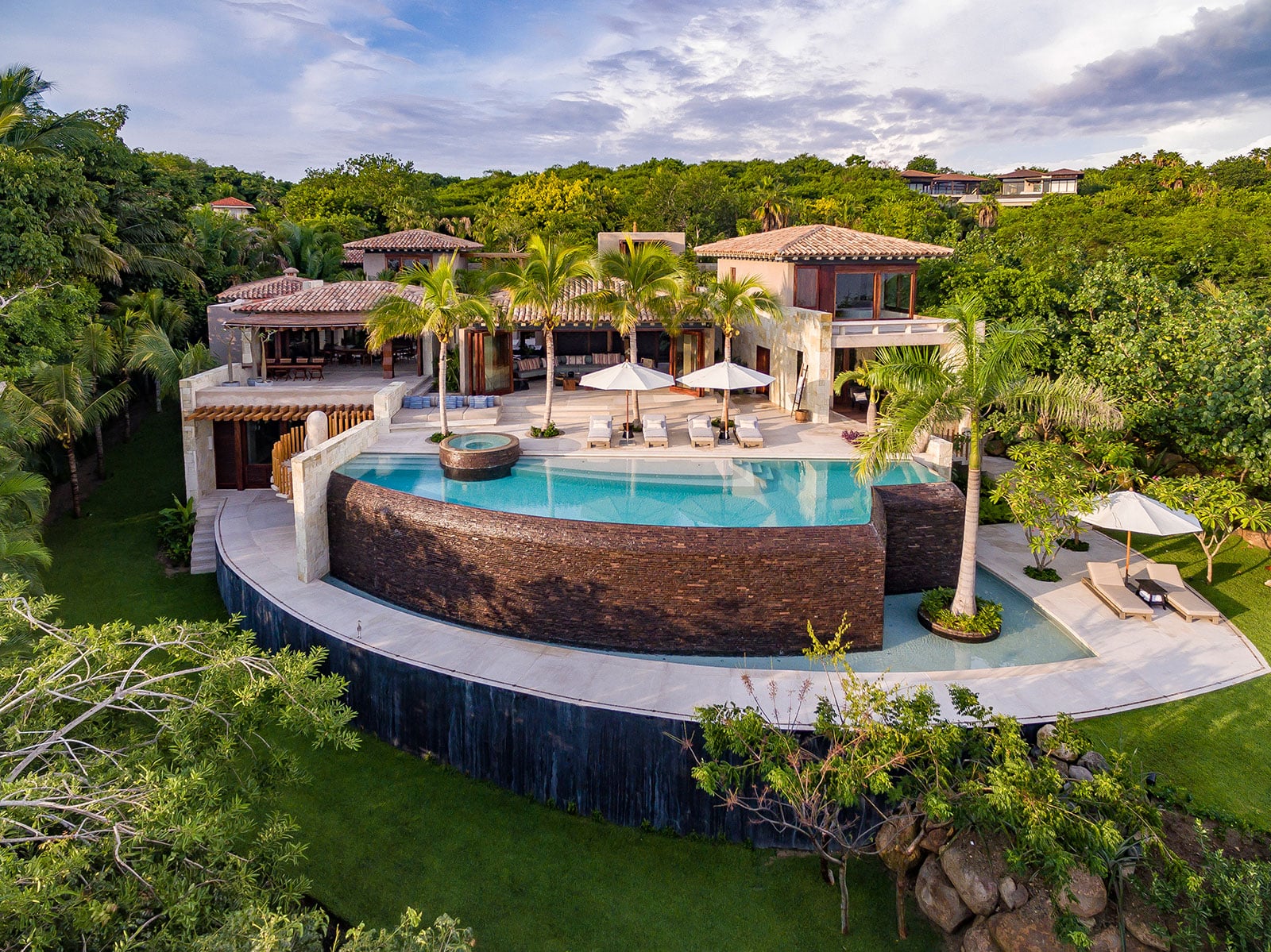 Luxury beachfront villa with infinity pool overlooking the Pacific — the kind of investment CFAR travel insurance protects
