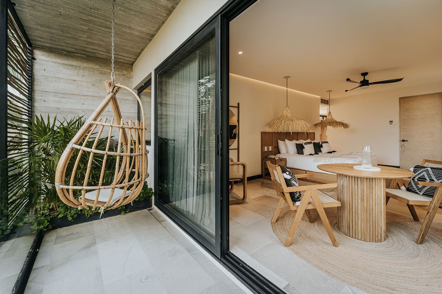 Azumaya Beach House bedroom with hanging rattan chair and boho pendant lights — Soliman Bay Tulum