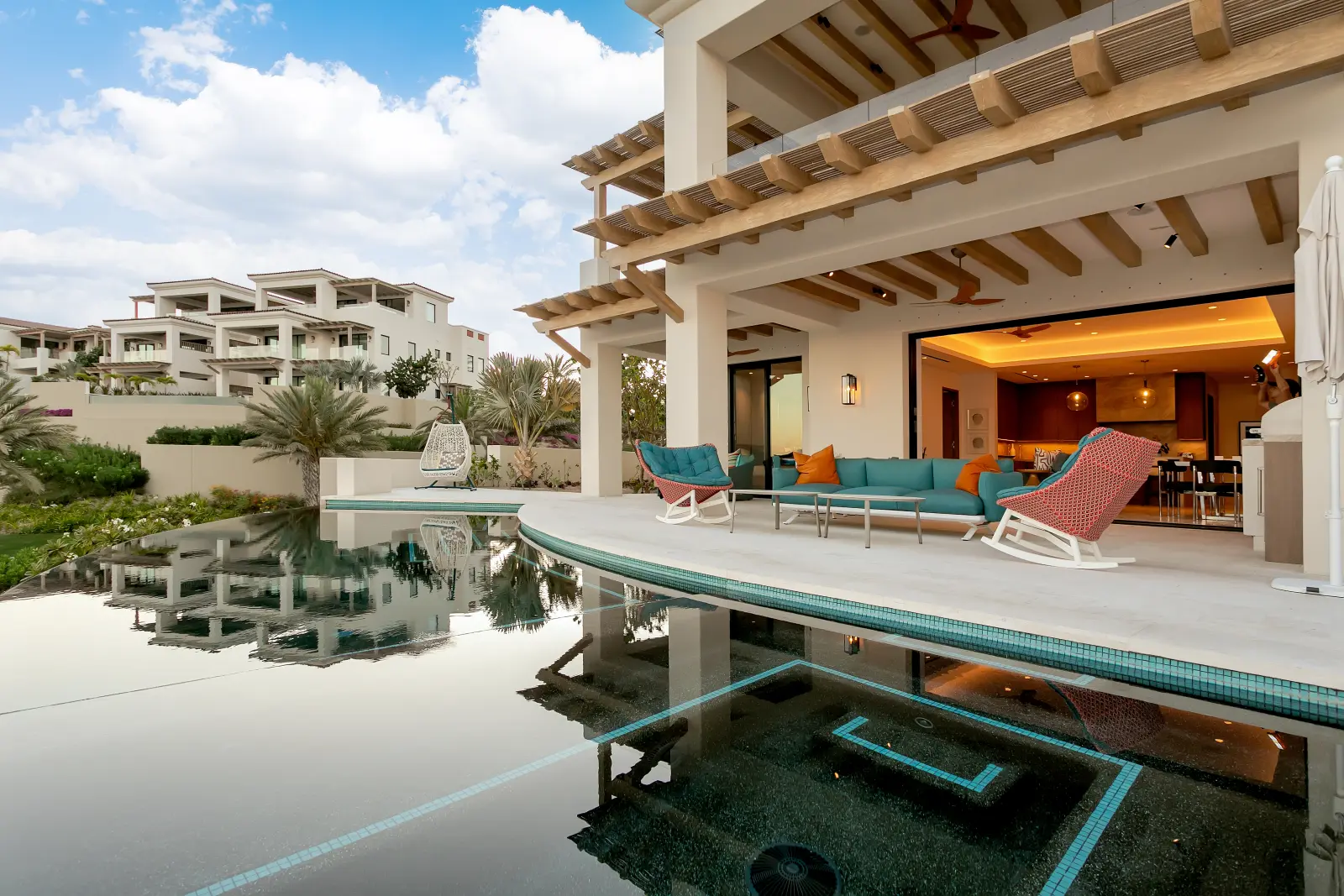 Bungalow 7 the terrace reflected in the still pool beside the wooden pergola — Los Cabos, Mexico