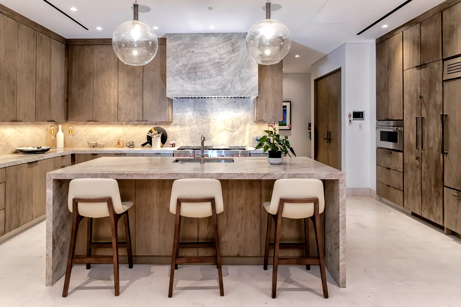Bungalow 7 kitchen island with three stools under two glass globe pendants — Los Cabos, Mexico