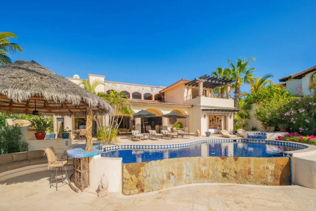 Casa Lolita the stone-clad bar and pool below the palapa at dusk — Los Cabos, Mexico