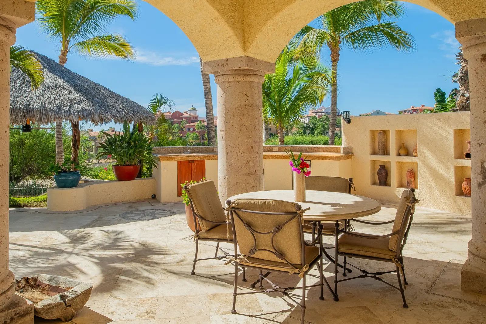 Casa Lolita round table and iron chairs on the arched terrace beside wall niches — Los Cabos, Mexico