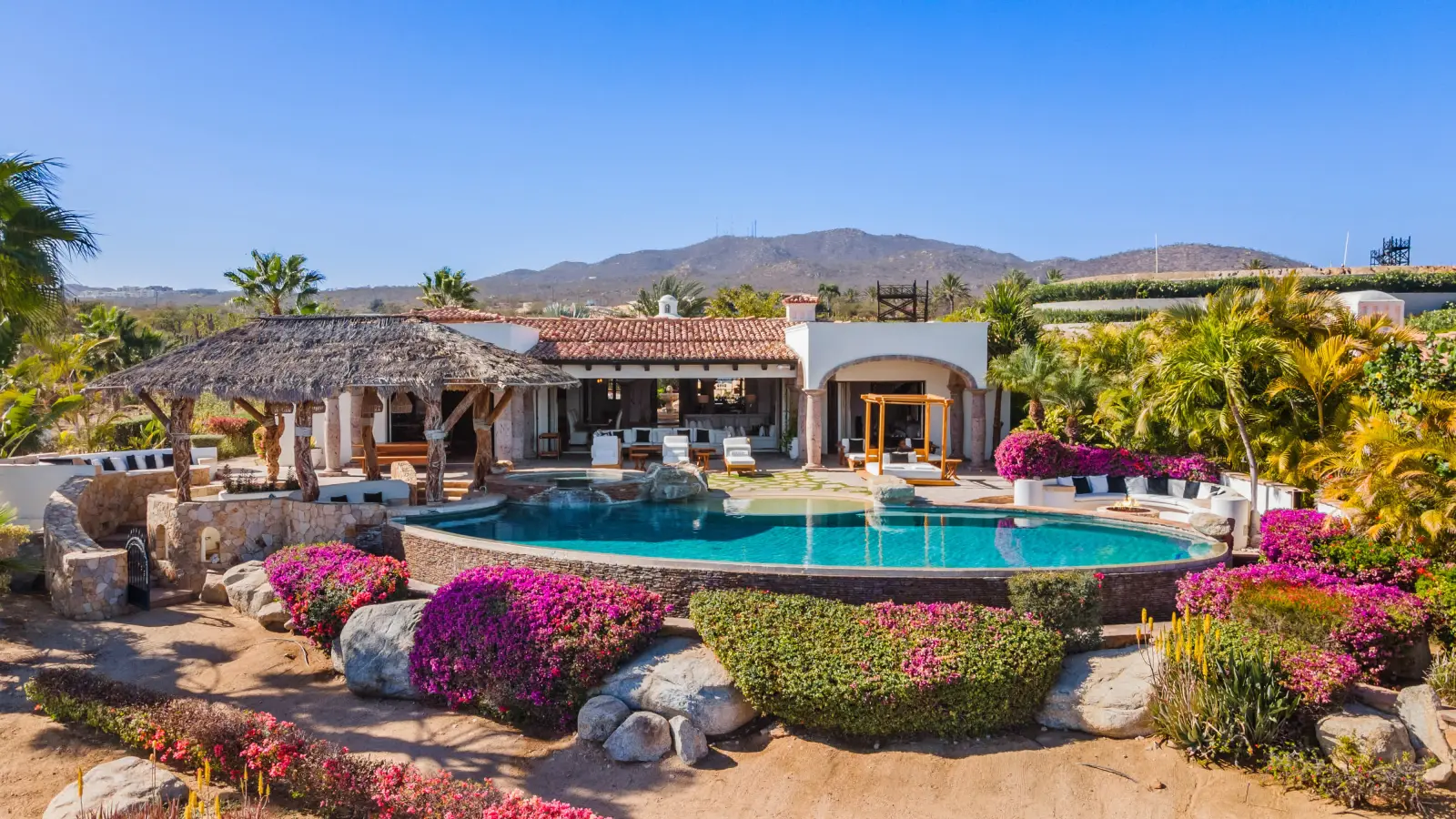 Casa Mar the curved pool and bougainvillea below the house and mountains — Los Cabos, Mexico