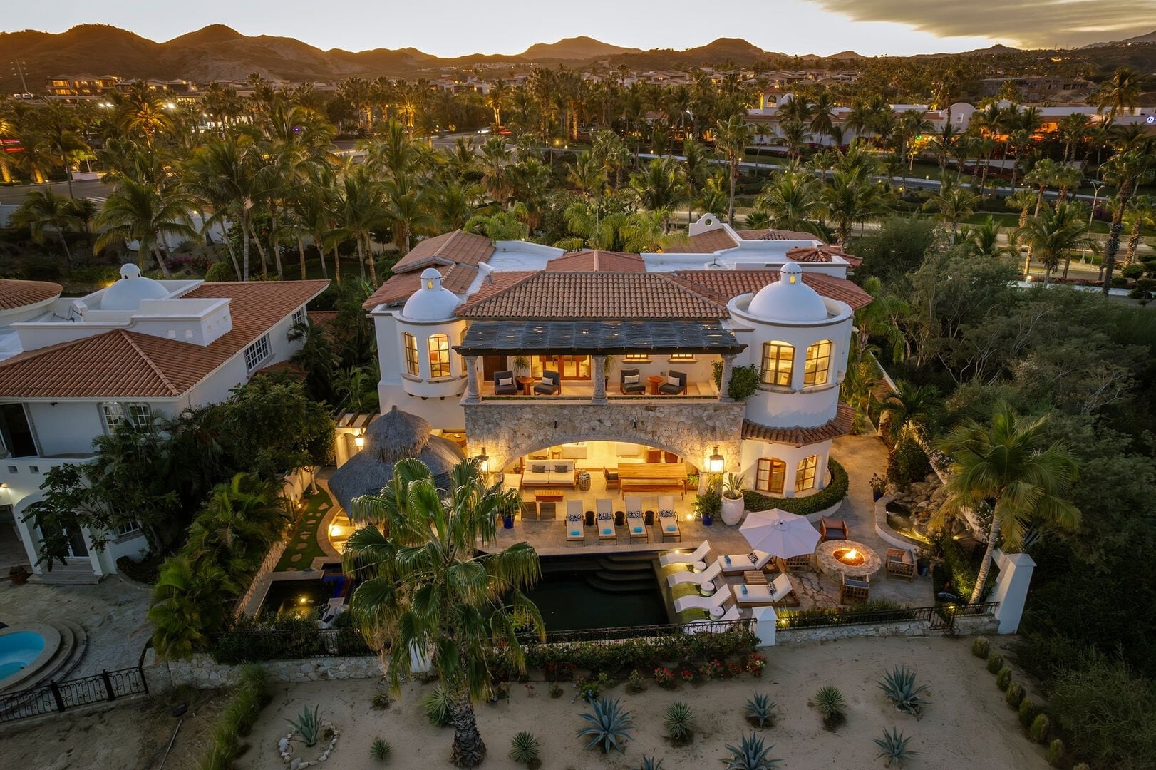 Casa Primera aerial view of the illuminated villa among palms — Los Cabos, Mexico