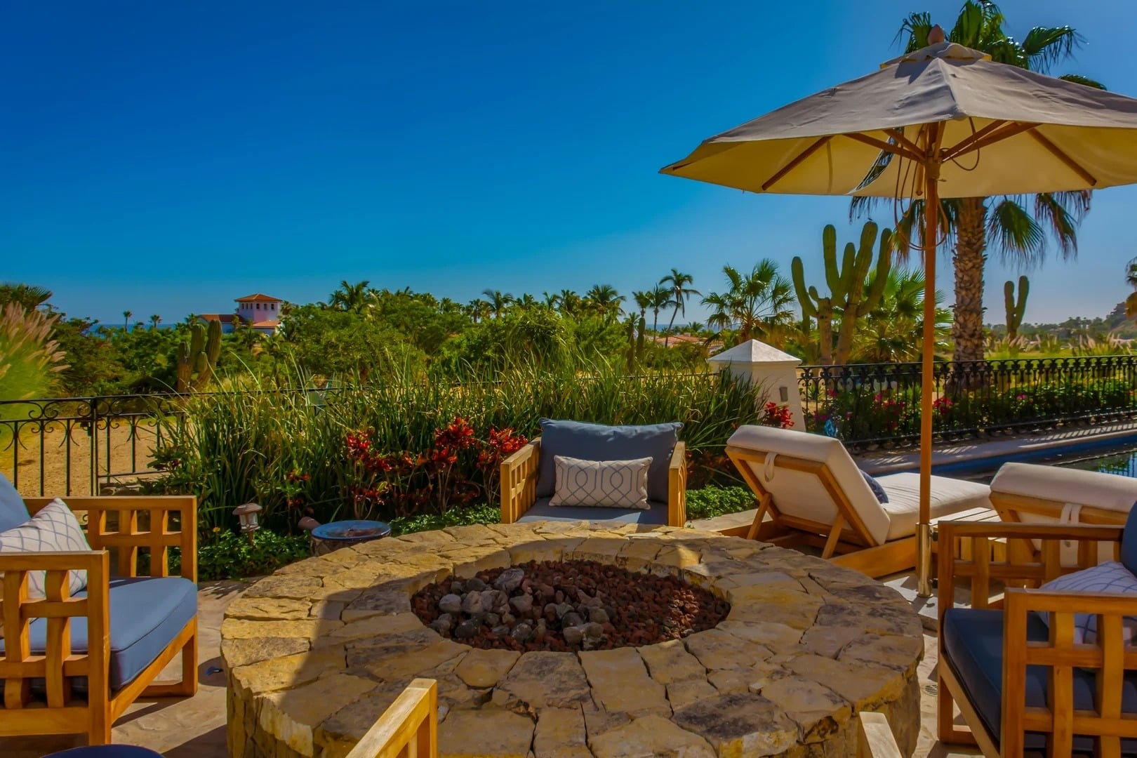 Casa Primera round fire pit with chairs and an umbrella on the terrace — Los Cabos, Mexico