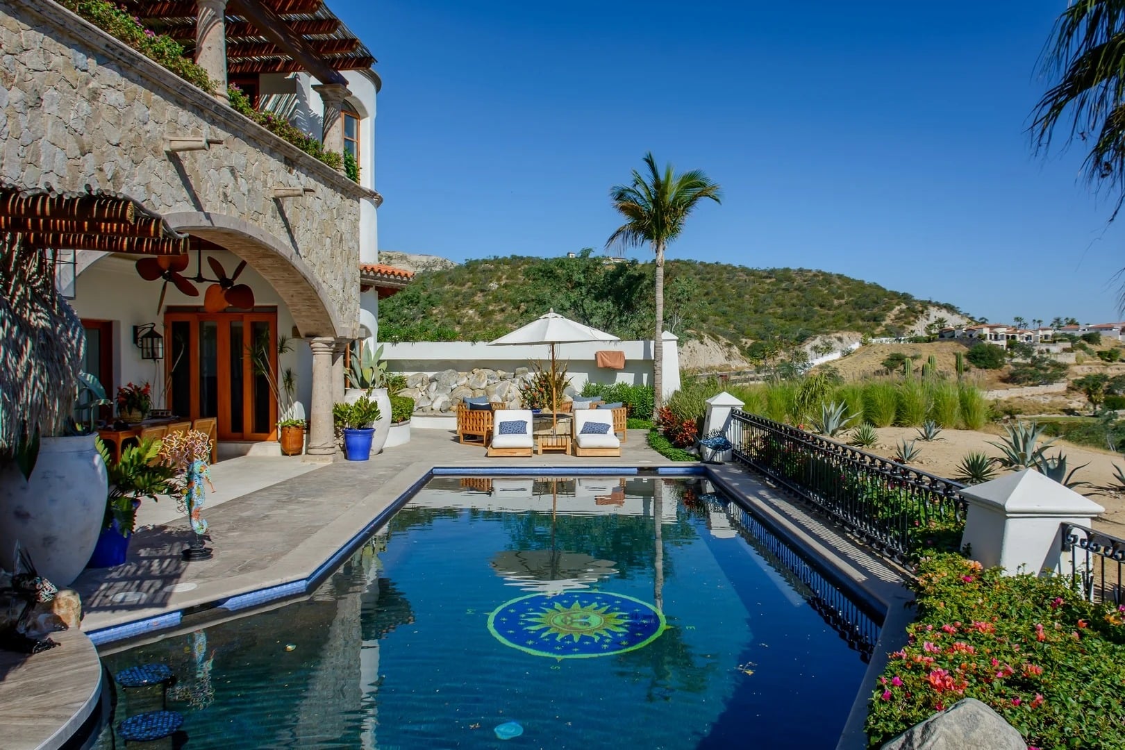 Casa Primera rectangular pool with a mosaic sun design and loungers — Los Cabos, Mexico