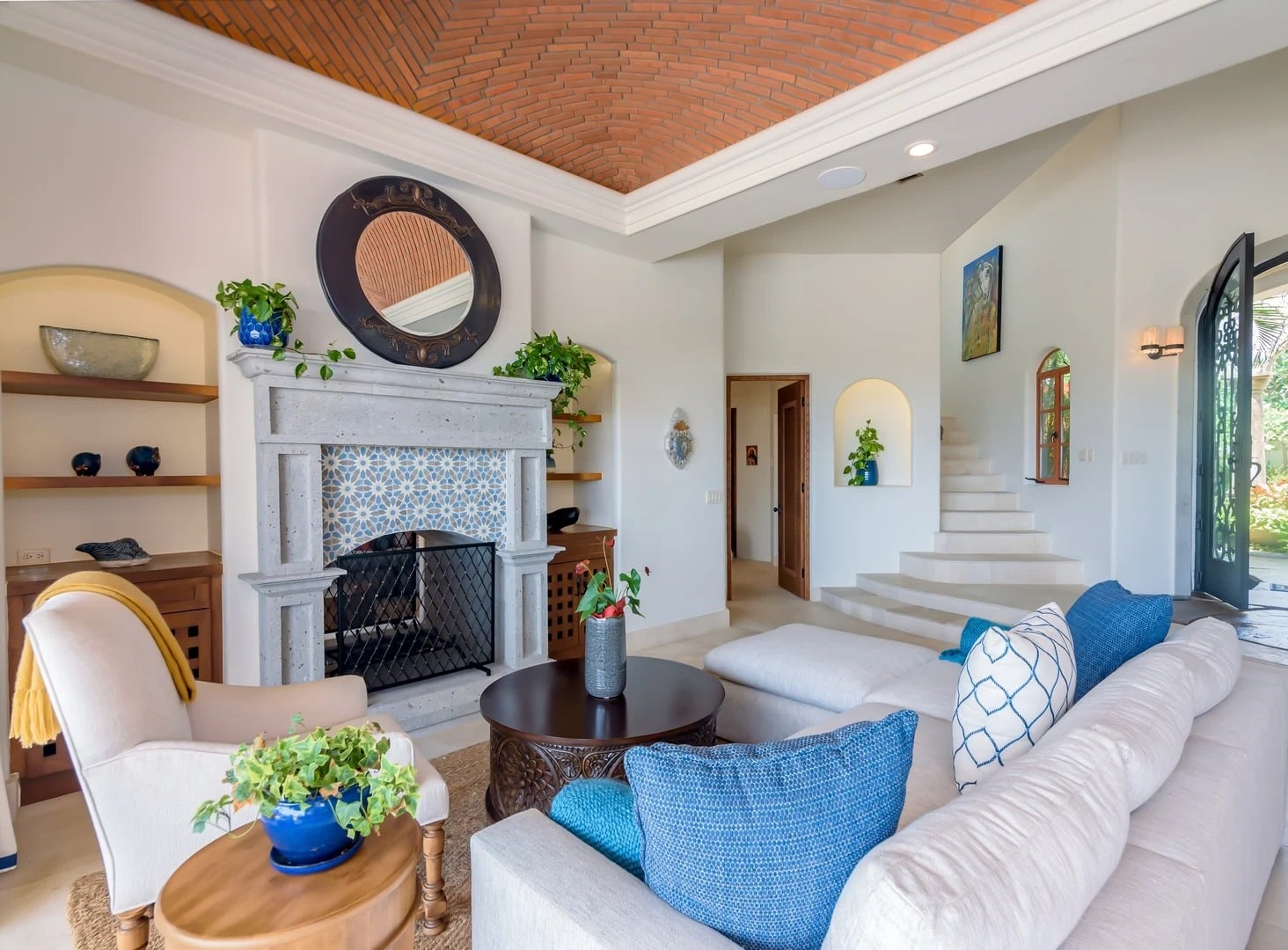 Casa Primera living room with a patterned fireplace and curved stairs — Los Cabos, Mexico