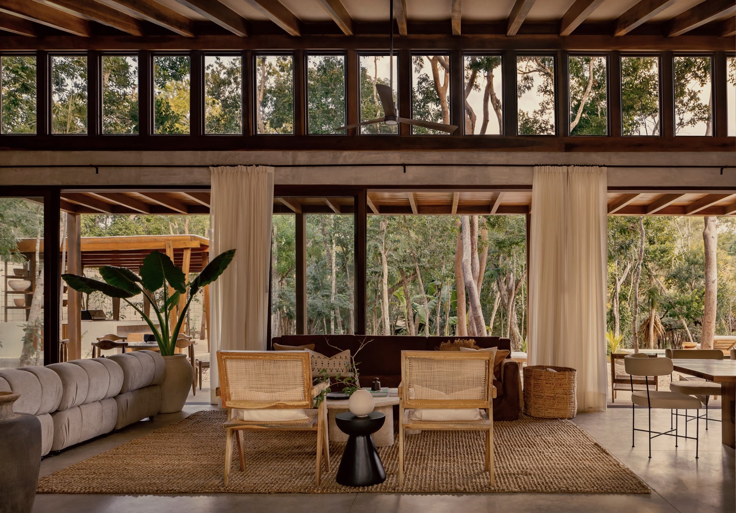 Casa Tropical double-height living room with rattan chairs and jungle views — Region 15 Tulum