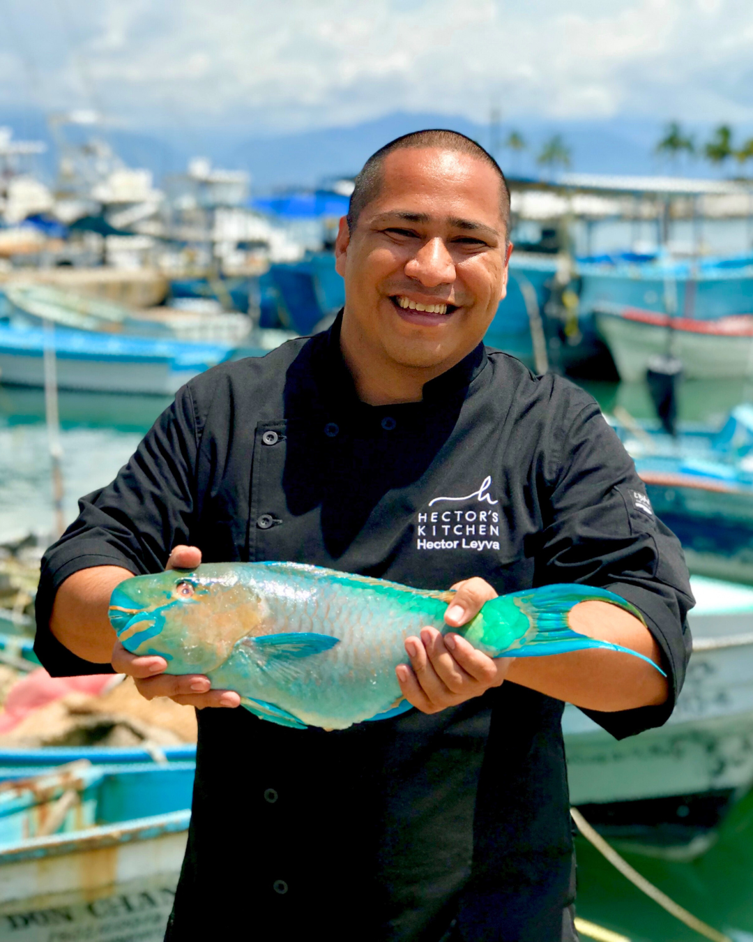 Chef selecting fresh-caught fish at La Cruz de Huanacaxtle marina fish market near Punta Mita