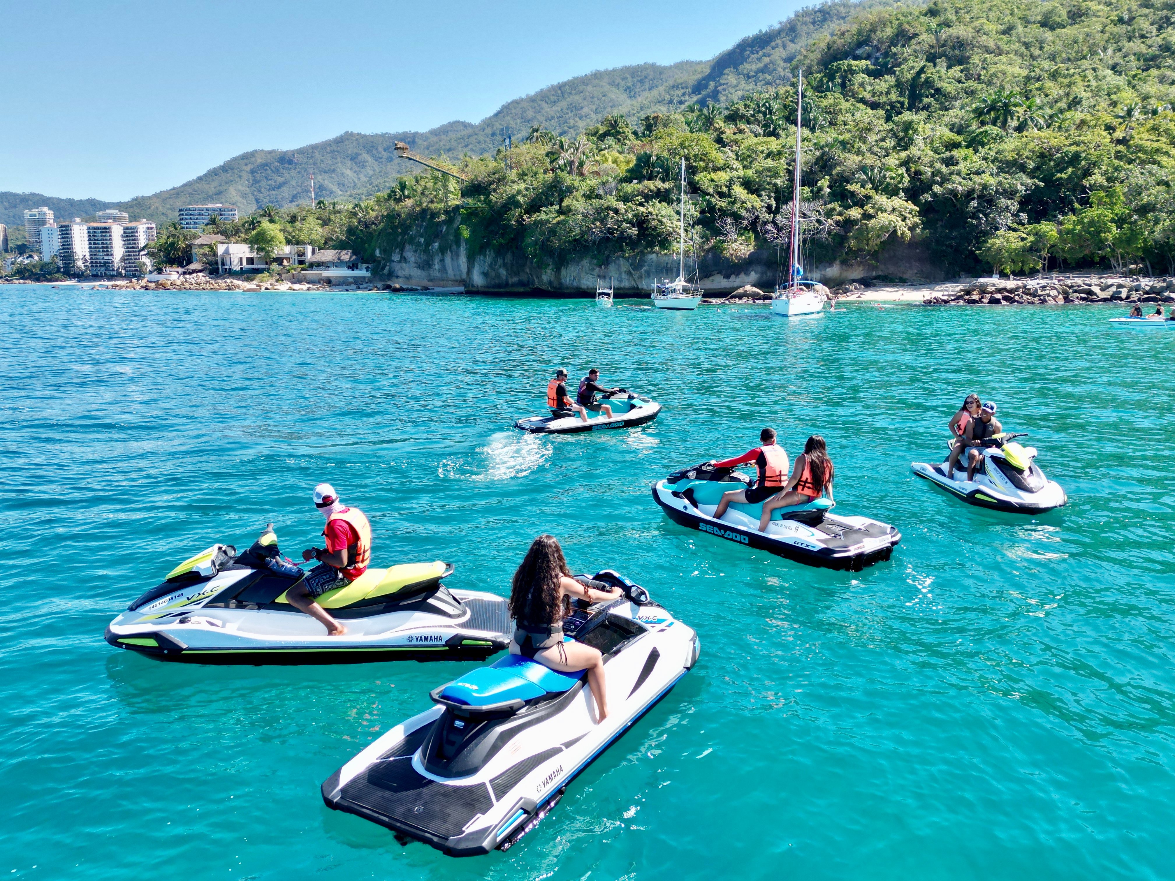 Jet ski tour speeding along Puerto Vallarta coastline with Sierra Madre mountains and Banderas Bay