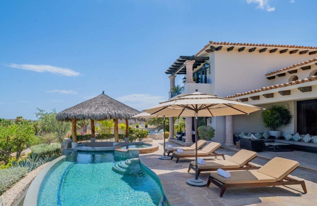 Villa Palmaritos 5 loungers and umbrellas along the pool below the tiled roof — Los Cabos, Mexico