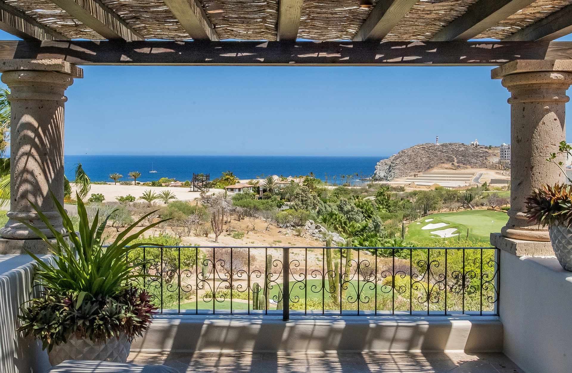 Villa Palmaritos 5 the ironwork balcony rail below a rustic pergola above the bay — Los Cabos, Mexico
