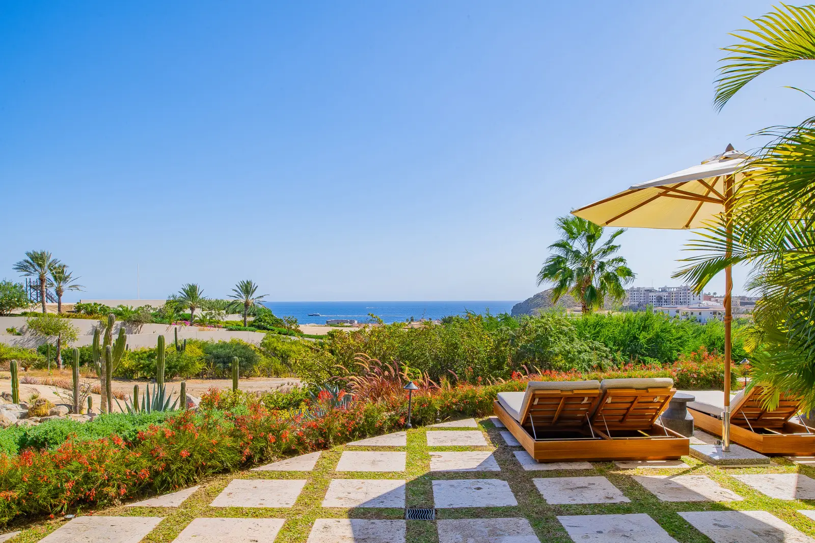 Villa Palmaritos 6 wooden loungers and an umbrella on the chequered stone paving — Los Cabos, Mexico