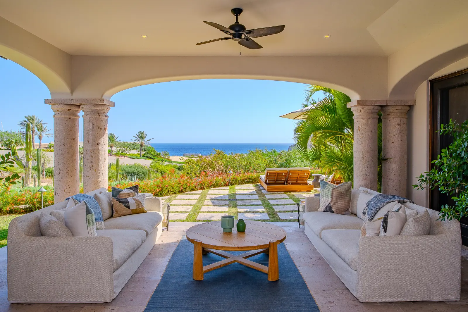 Villa Palmaritos 6 two sofas and a round wood table under the arched loggia — Los Cabos, Mexico