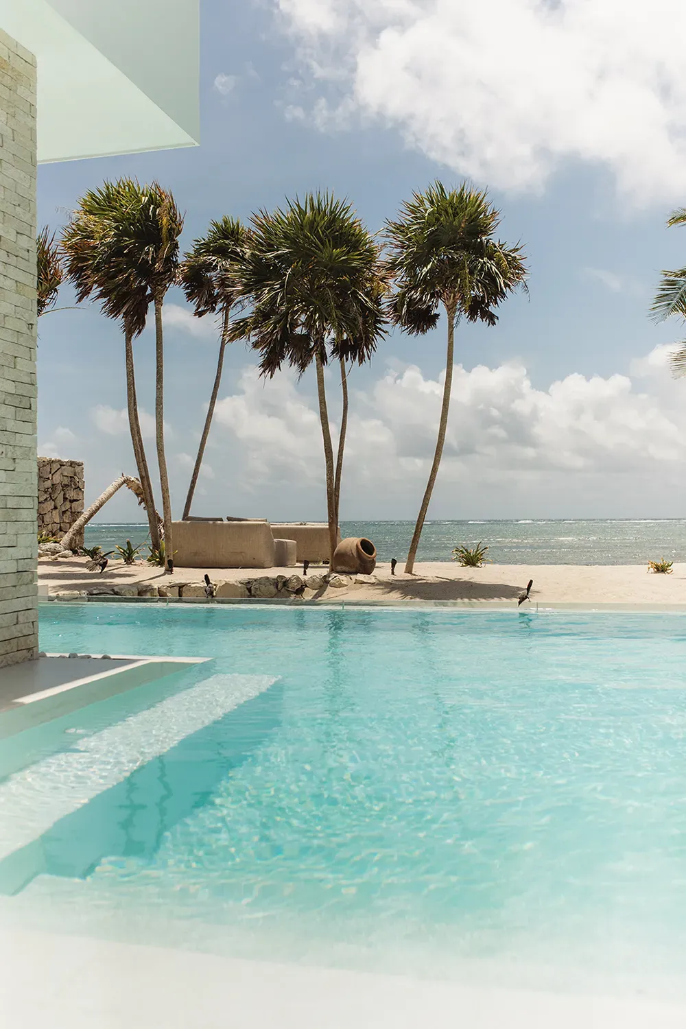 Studio 54 shallow pool steps facing palm trees and the ocean — Tulum, Mexico