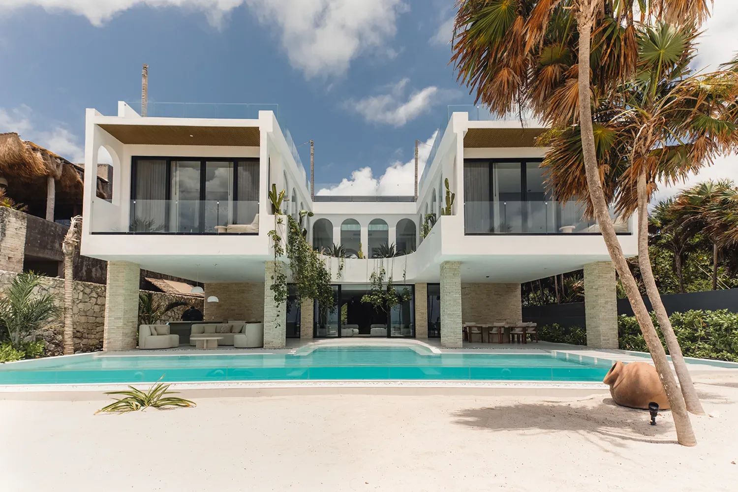 Studio 54 white beachfront facade with a pool and arched upper walkway — Tulum, Mexico