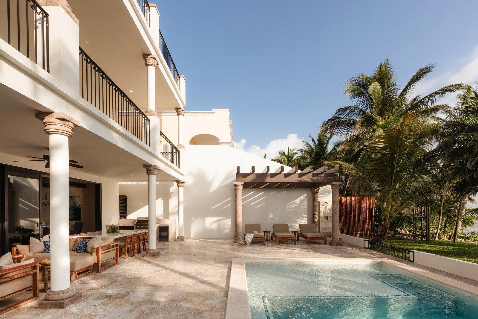 Villa Dulce Vida pool terrace with lounge chairs, a pergola, and villa facade — Riviera Maya, Mexico