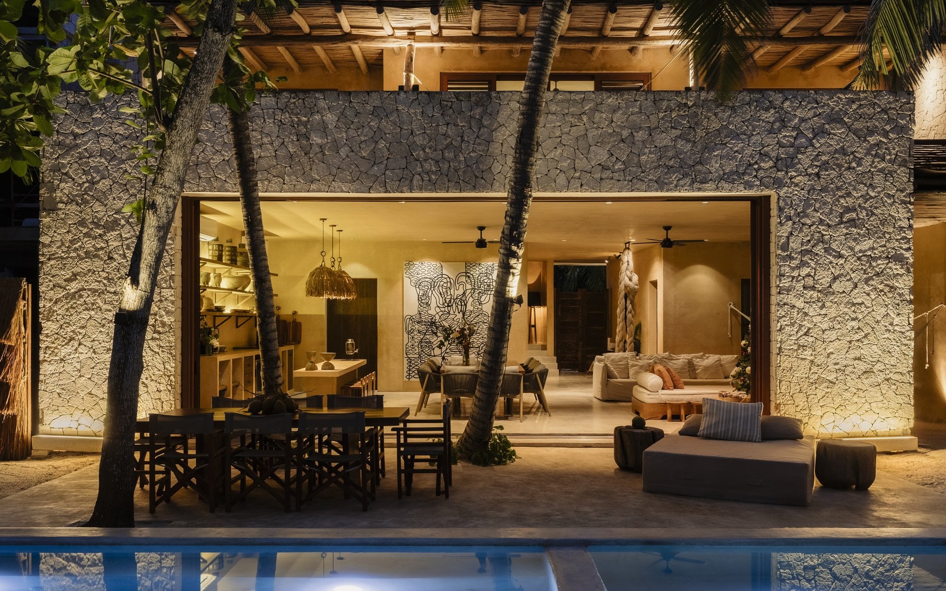 Villa Mariola illuminated facade reflected in the pool at dusk — Tulum, Mexico
