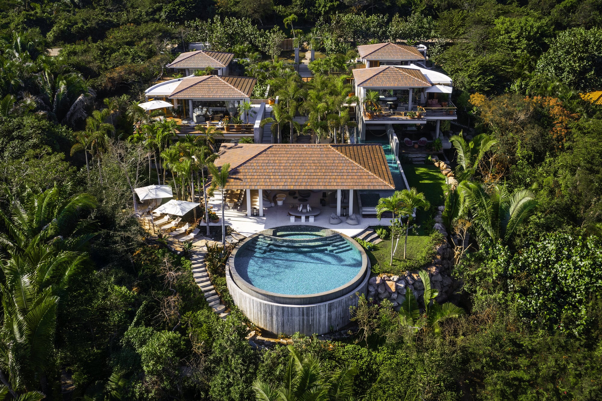 Casa Koko Iyari aerial of a round pool and tiled-roof pavilions surrounded by palms — Punta Mita Nayarit, Mexico