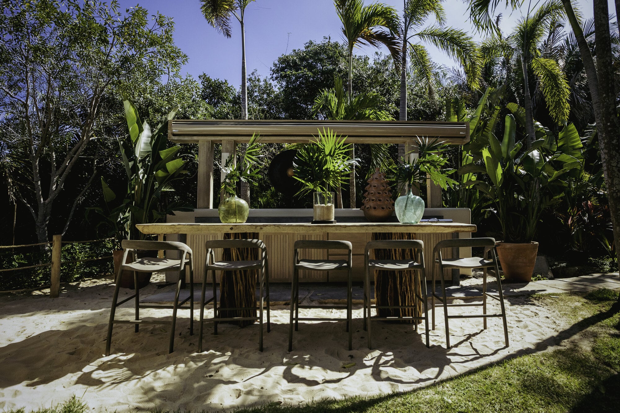 Casa Koko Iyari outdoor bar with six stools on sand amid tropical plants — Punta Mita Nayarit, Mexico