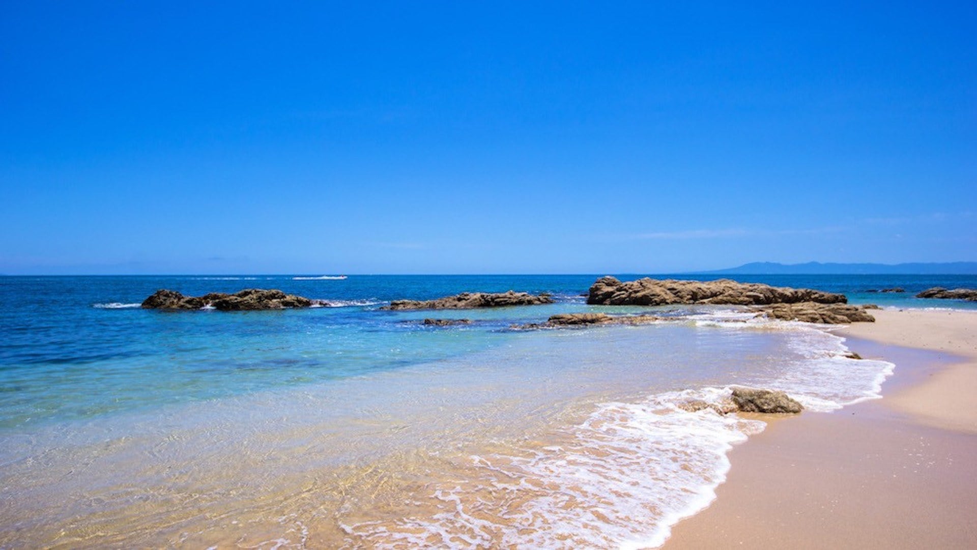 Villa Verde sandy beach with low rocks and blue water — Puerto Vallarta, Mexico