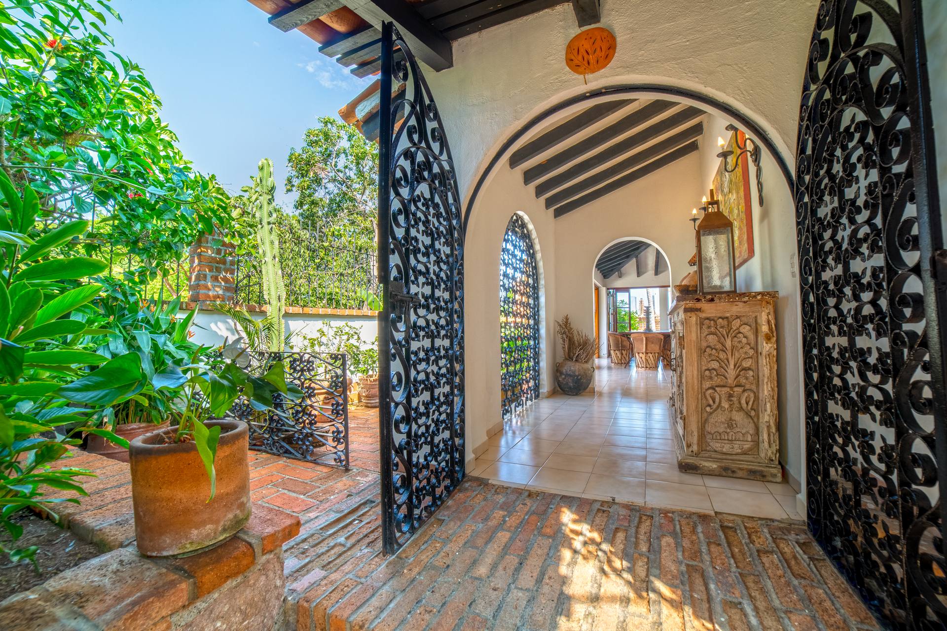 Villa Veranda black patterned doors opening to an arched entry corridor — Puerto Vallarta, Mexico