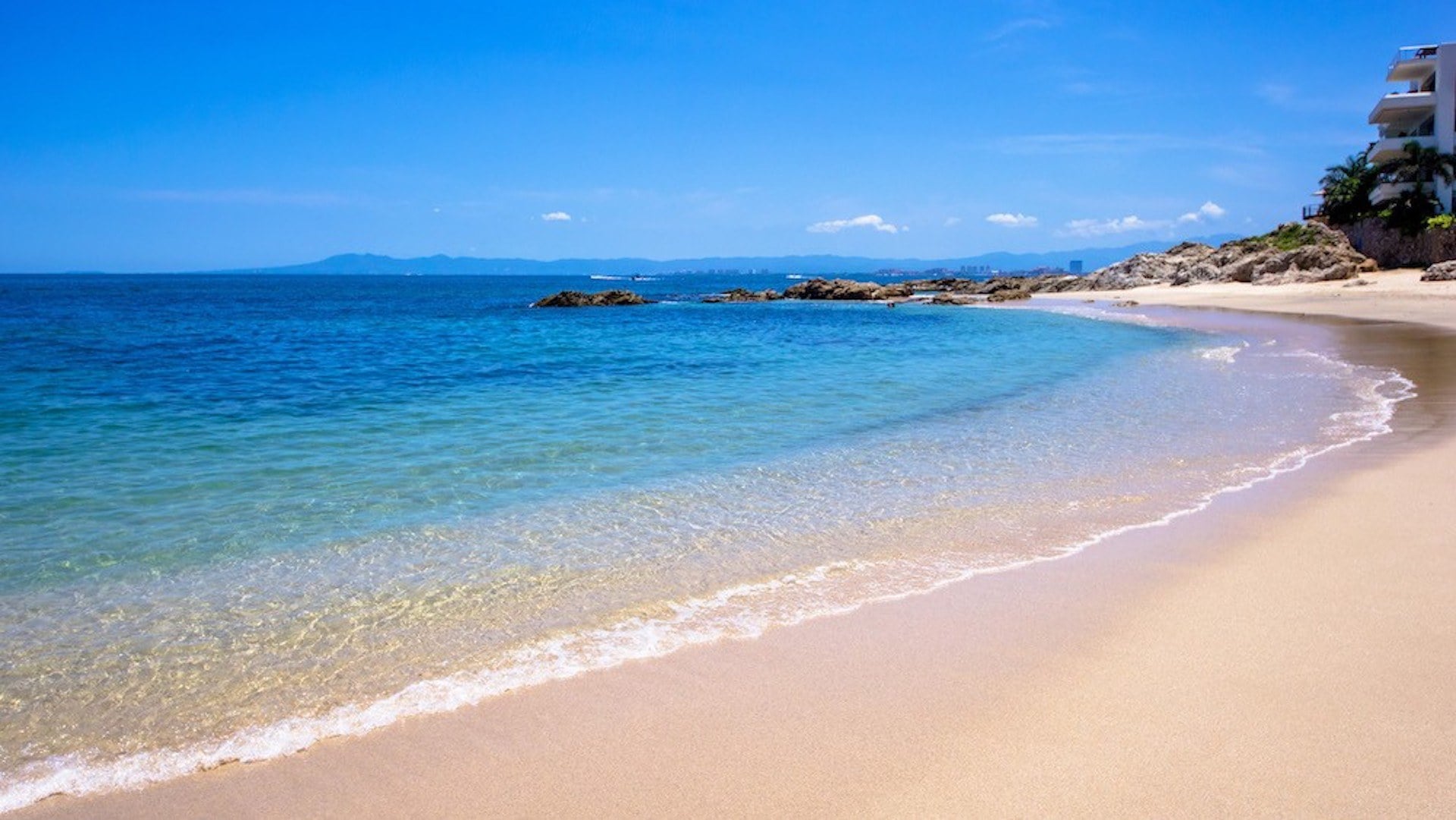 Villa Verde clear water meeting a curved sandy shoreline — Puerto Vallarta, Mexico