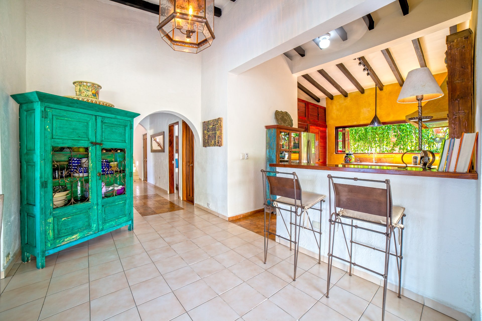 Villa Veranda dining and kitchen area with a turquoise cabinet and counter stools — Puerto Vallarta, Mexico
