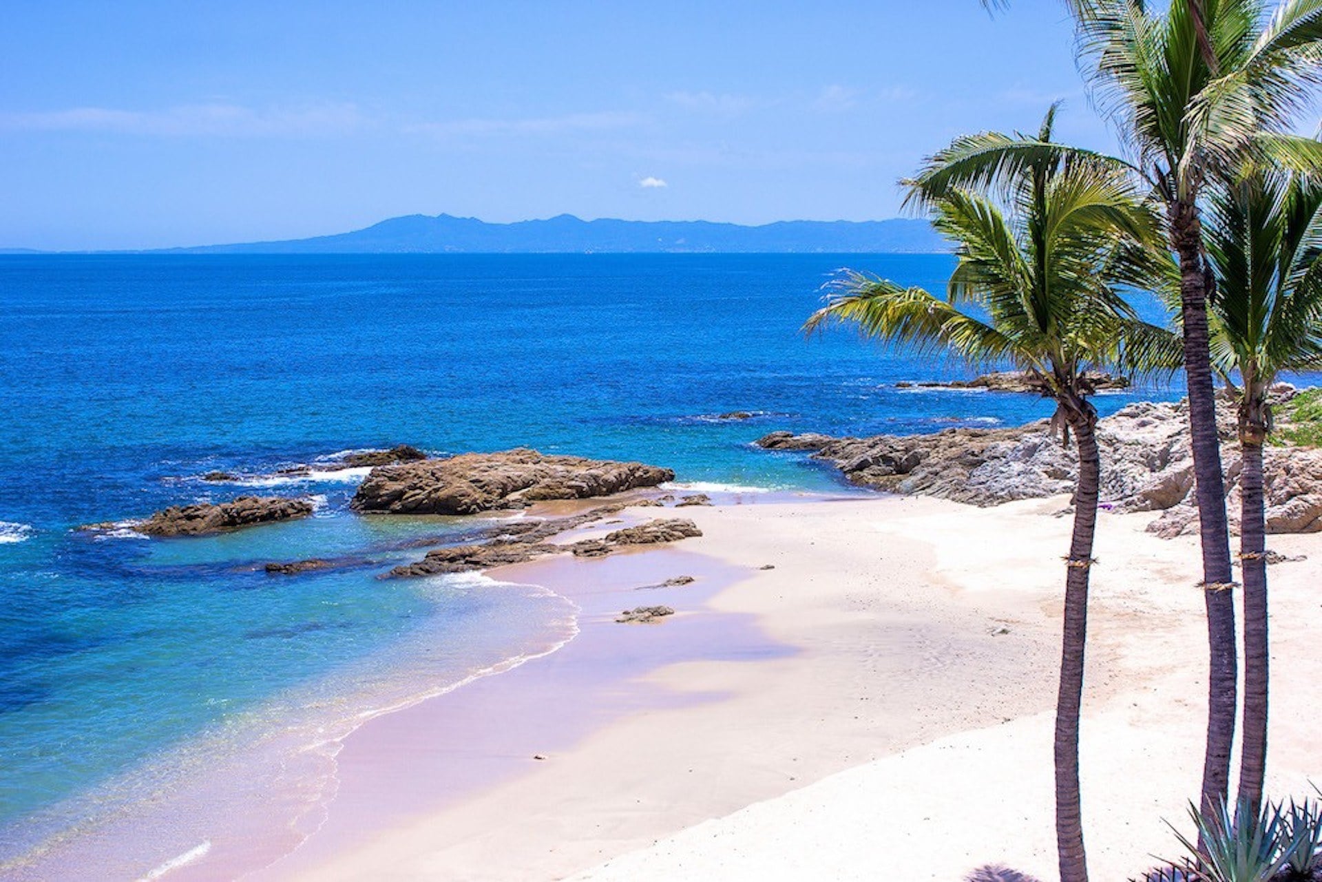 Villa Verde palm-framed sandy cove and rocky coast — Puerto Vallarta, Mexico