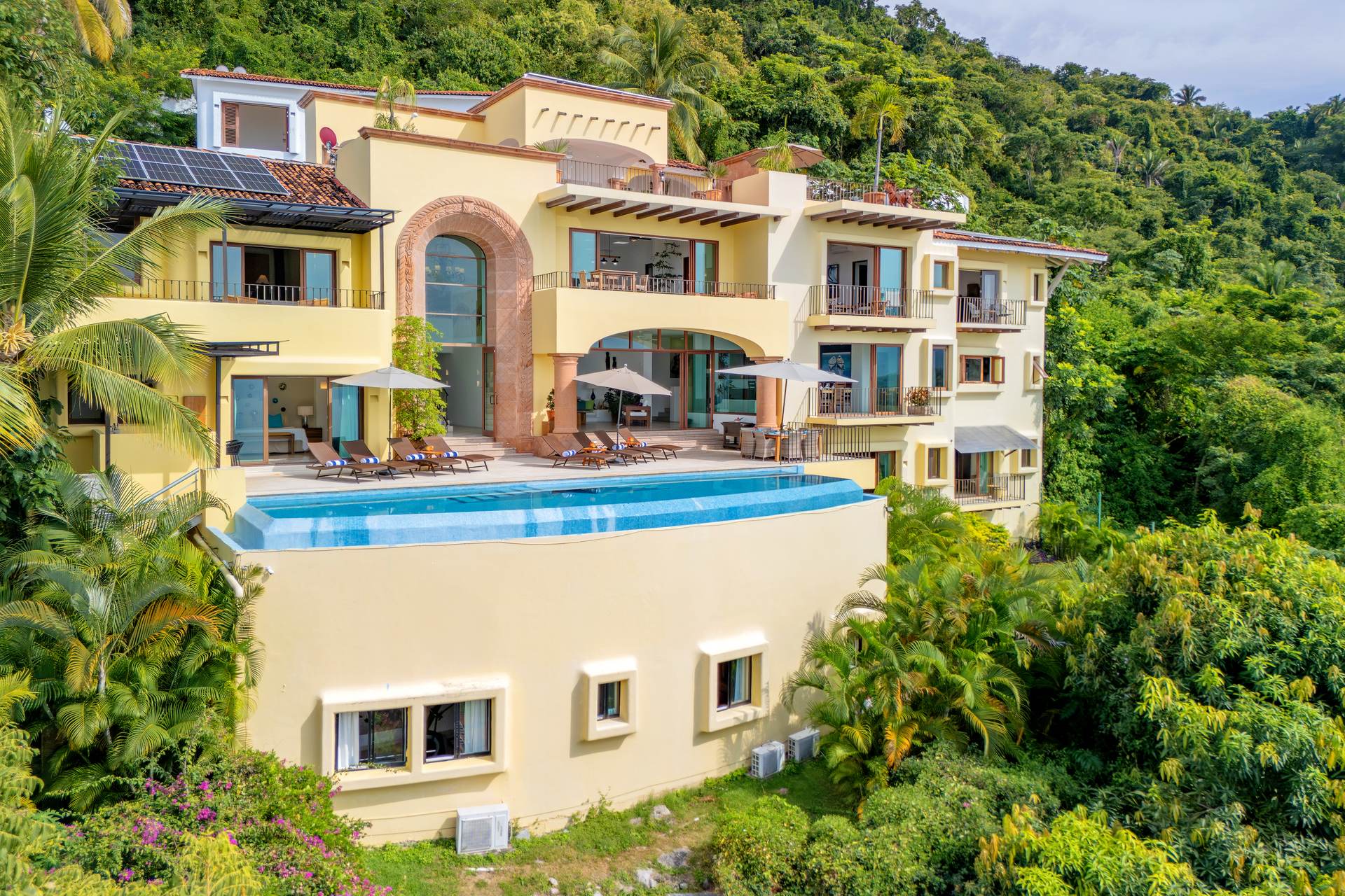 Villa Santa Cruz villa exterior and raised pool surrounded by green hillside — Puerto Vallarta, Mexico