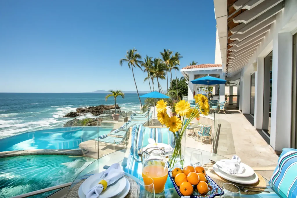 Casa Karma breakfast table with fruit and juice beside the oceanfront pools — Puerto Vallarta, Mexico