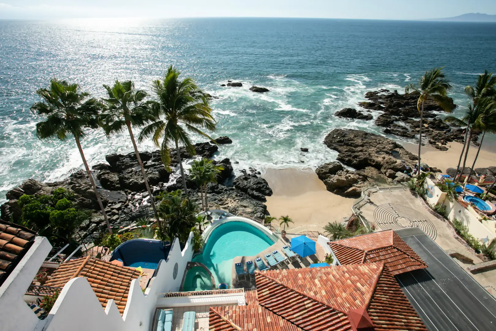 Casa Karma aerial view of the pool terrace beside a rocky cove — Puerto Vallarta, Mexico